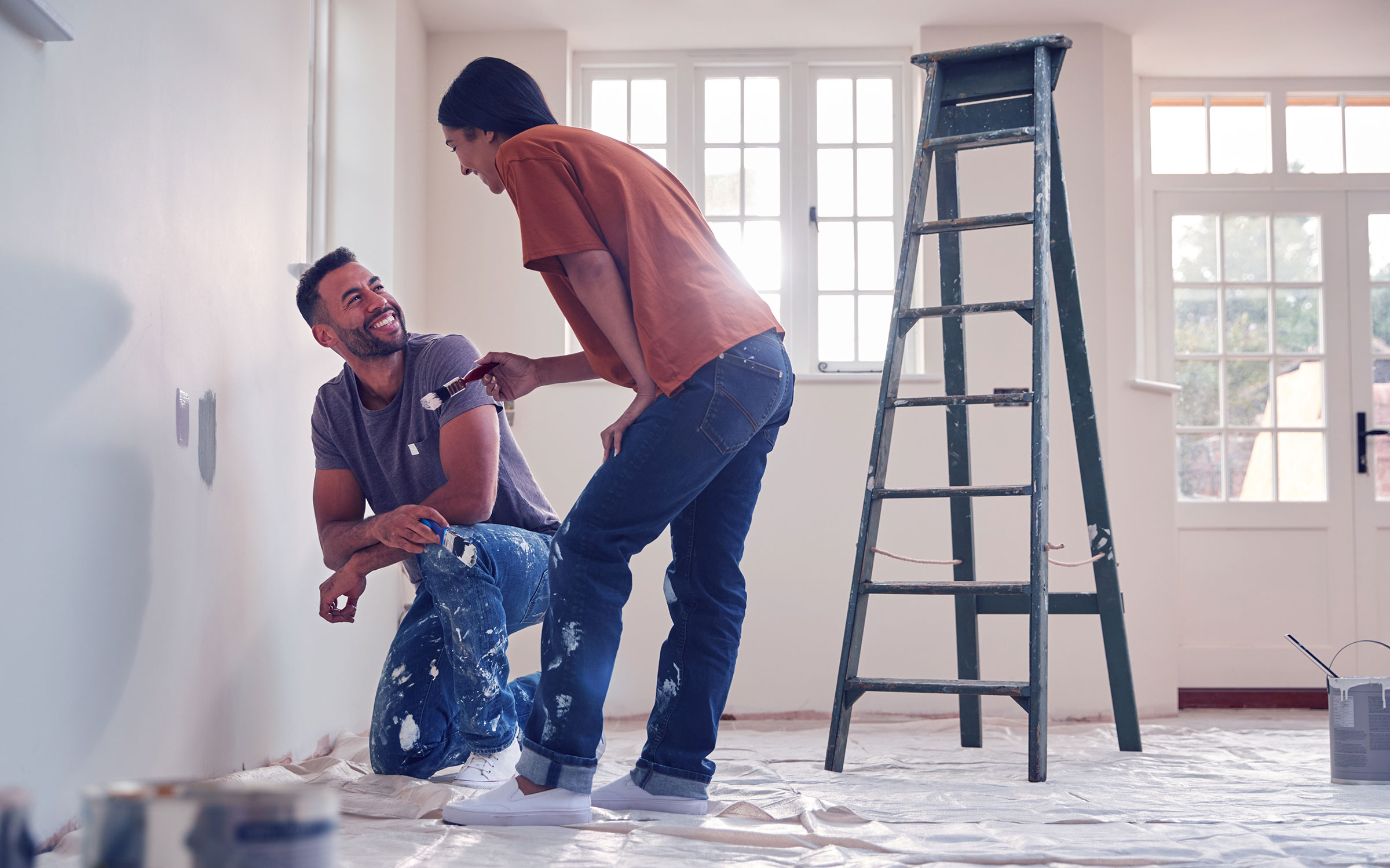 Couple painting room together