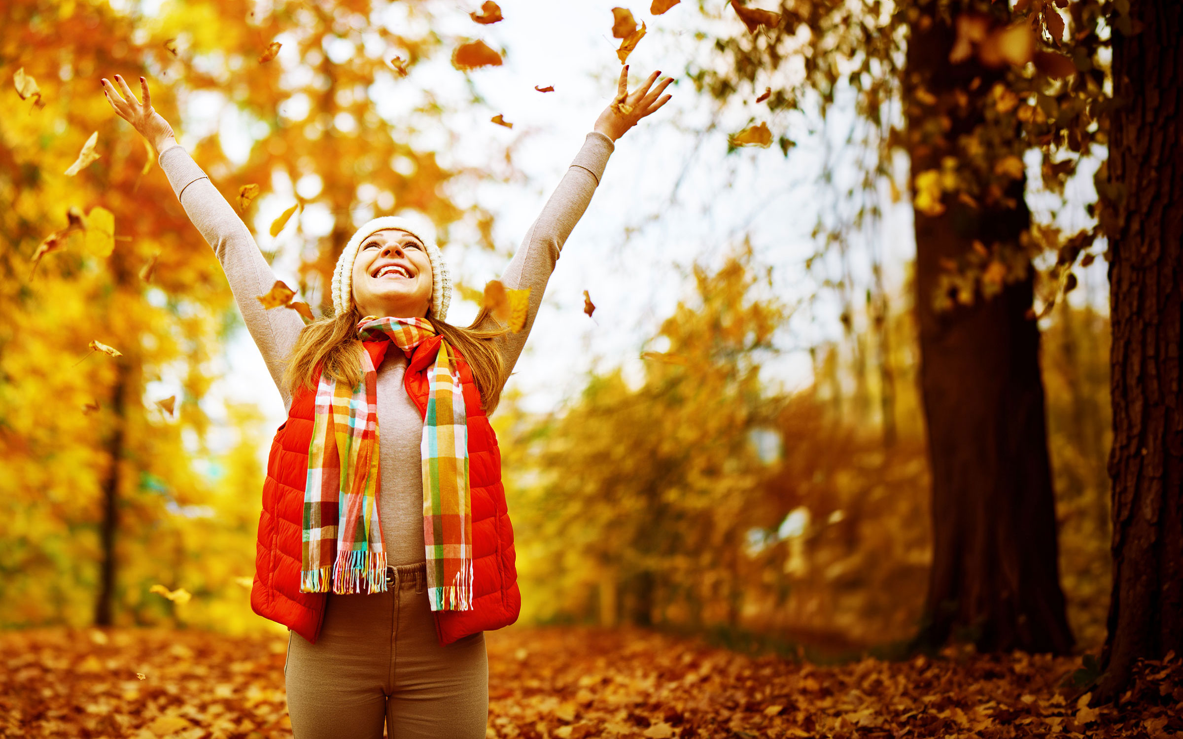 Woman tossing leaves into the air
